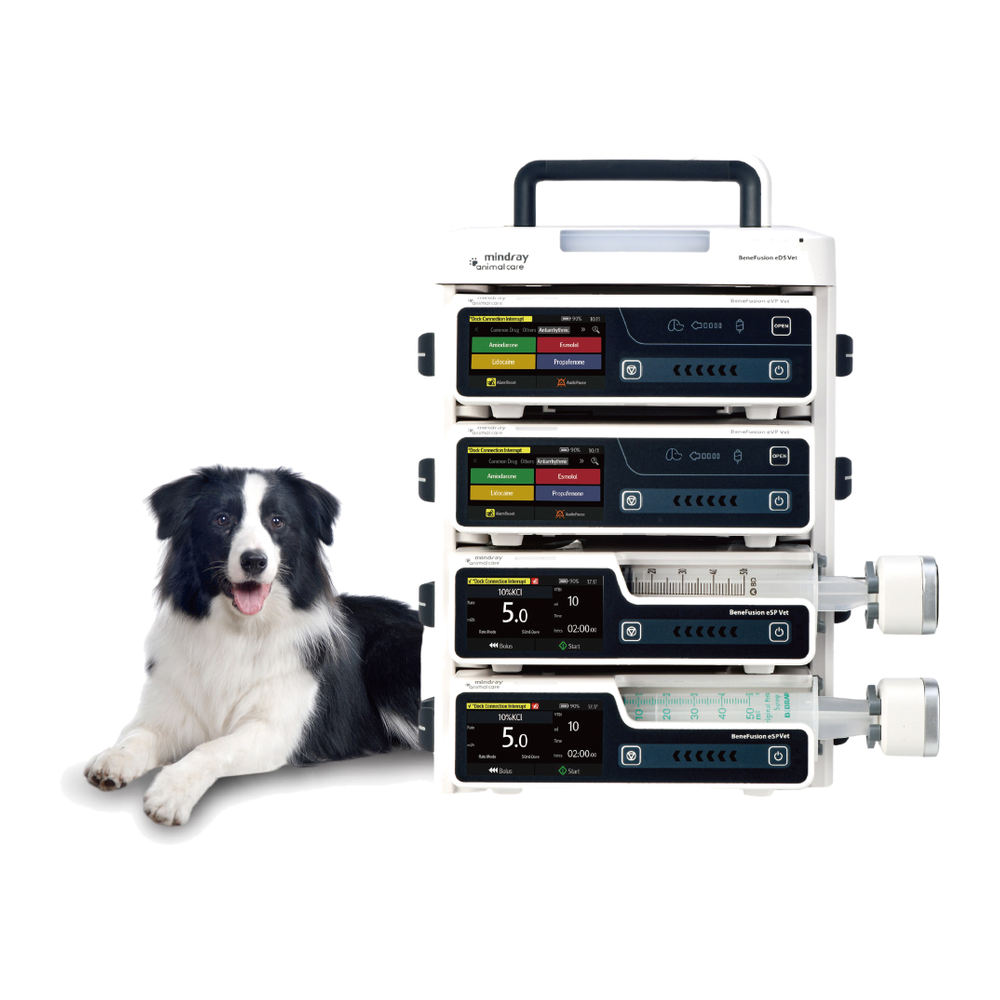 Four Mindray BeneFusion pumps stacked in an eDS Vet docking station beside a border collie