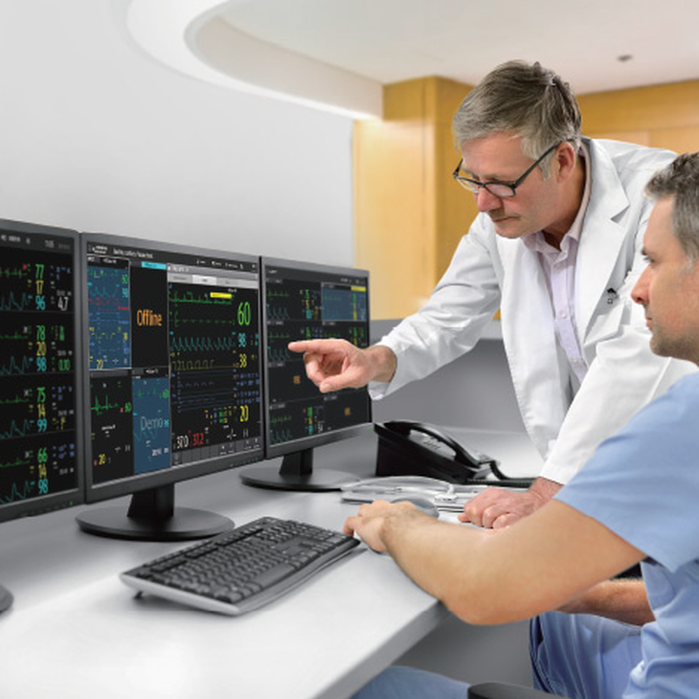 Two clinicians reviewing patients on a three-screen BeneVision CMS Vet CentralStation