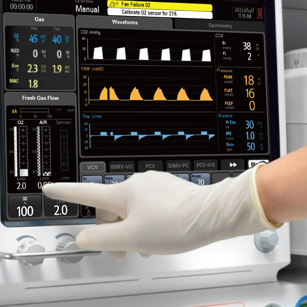 Gloved finger touching the fresh gas controls on a Mindray WATO EX-65 Pro Vet touchscreen, with gas readings and three waveforms on screen